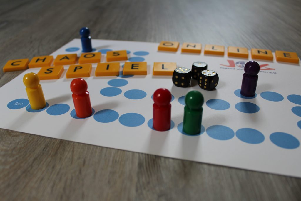 Spielfeld mit Figuren und Text "Chaosspiel Online"